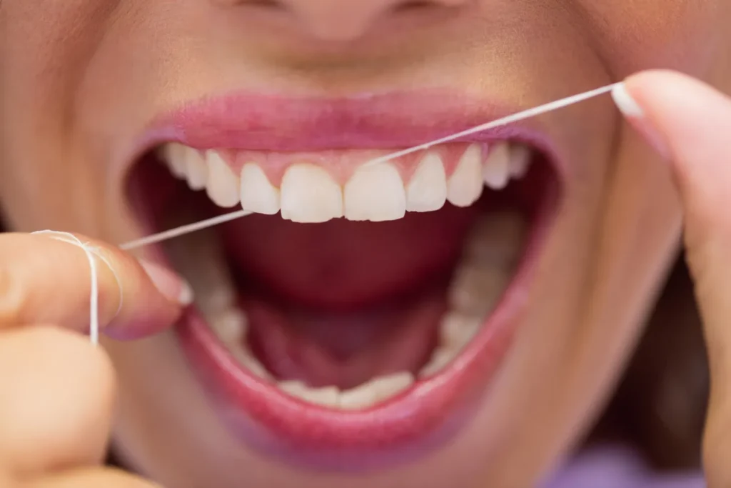 Close-up of correct dental flossing technique between the front teeth.