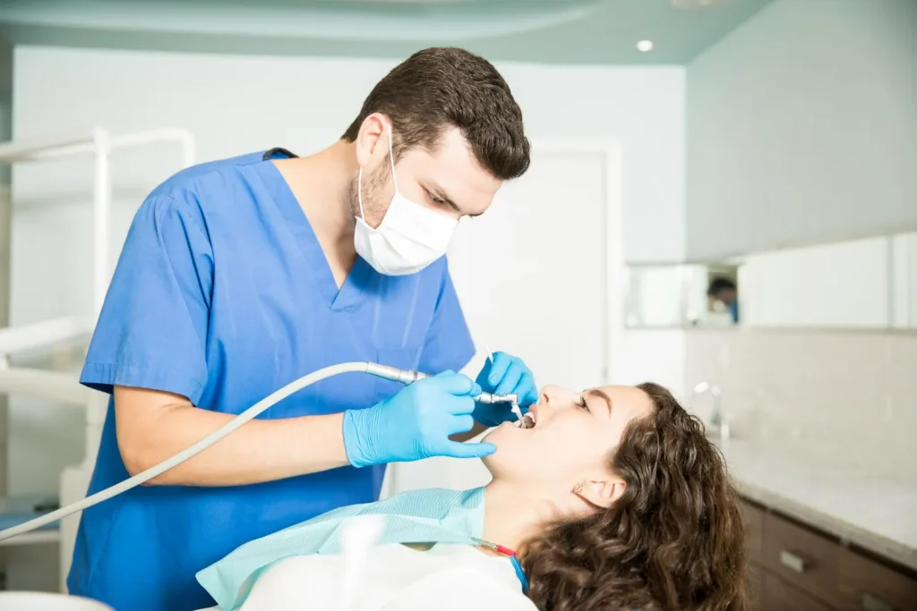 Dental hygienist performing a professional teeth cleaning treatment.