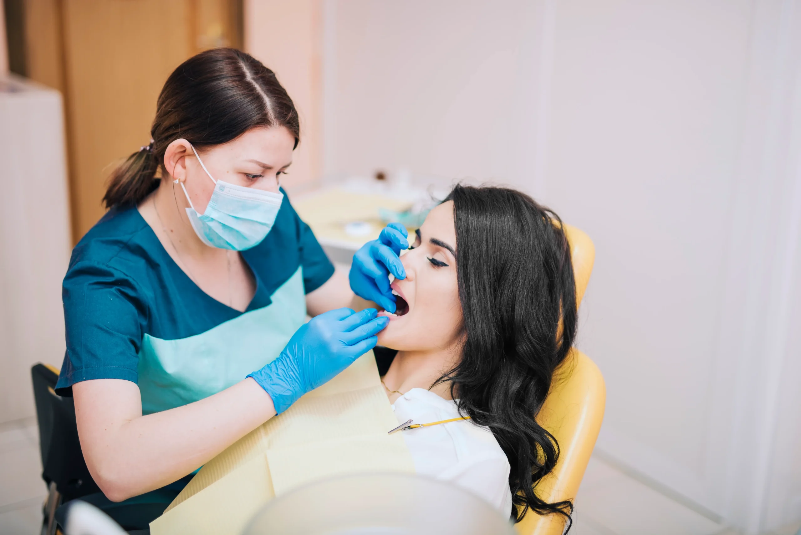 Dentist examining a patient during a dental appointment about oral health and mouth guard care.